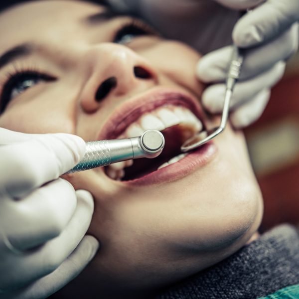 The dentist examines the patient's teeth.